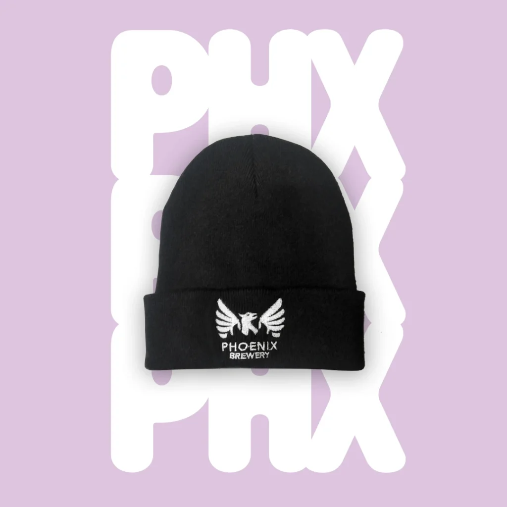 Black Phoenix Brewery beanie with white embroidered phoenix logo on a lilac background with white "PHX" stacked text