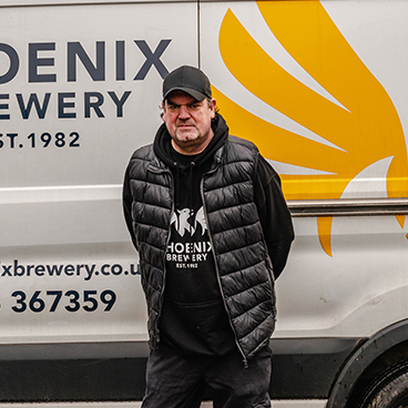 Phoenix Brewery team member Andy standing next to a Phoenix Brewery van