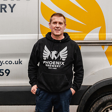 Phoenix Brewery team member Andy standing next to a Phoenix Brewery van