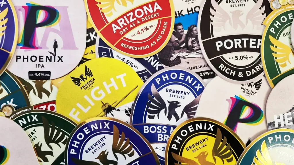 Various Phoenix Brewery beer labels, including Phoenix IPA, Arizona, and Porter, arranged in a colorful collage.